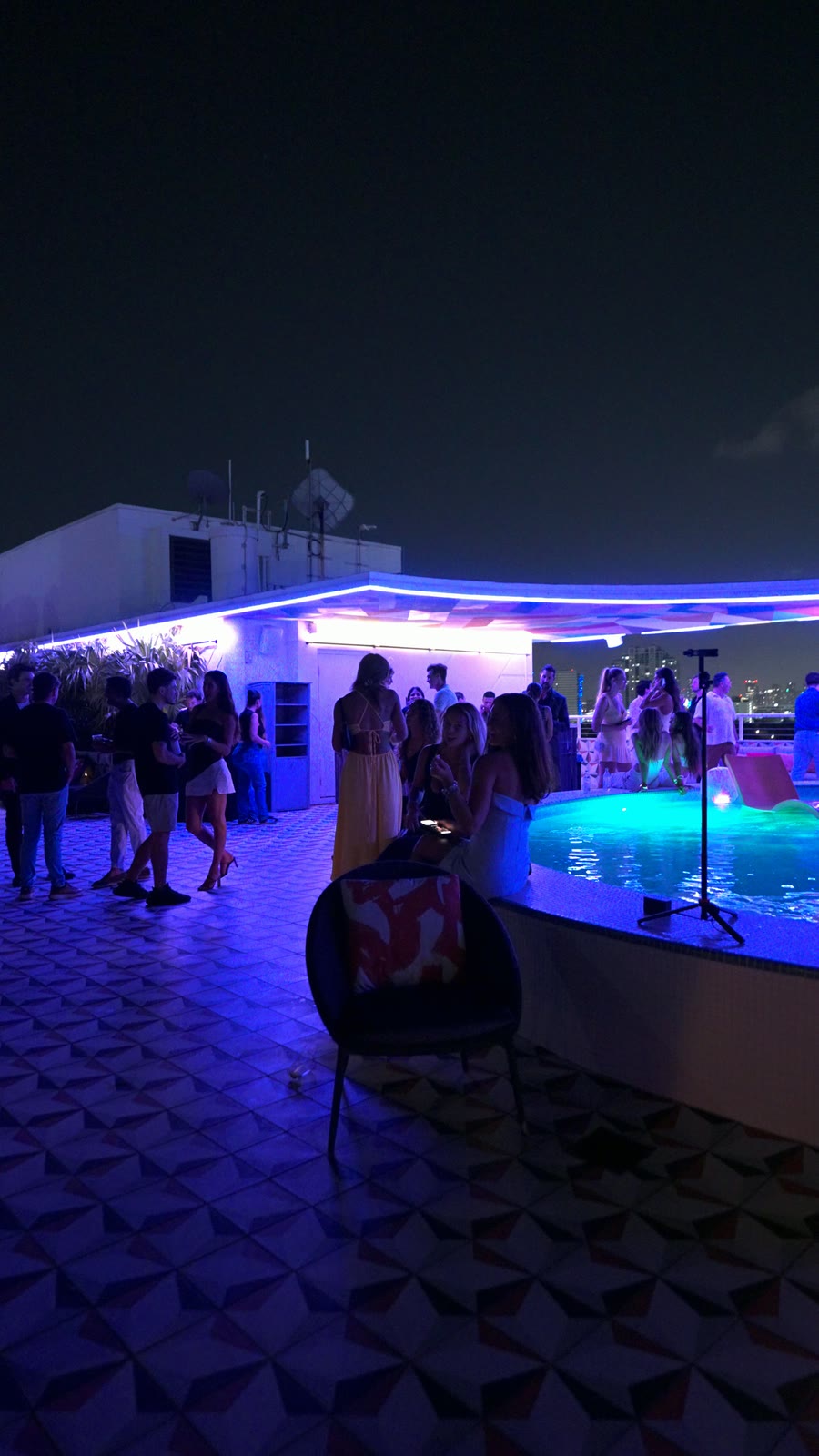 The Miami rooftop pool at dusk under purple light